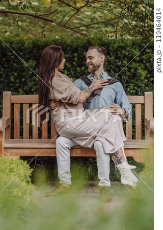 Happy loving couple enjoying their time together in park. Loving couple spending time together. Girl with tattoos. Tattooed woman. Beautiful fashionable couple of lovers on the street. Happy loving couple enjoying their time together in park. Loving couple spending time together. Girl with tattoos. Tattooed woman. Beautiful fashionable couple of lovers on the street. 119464014
