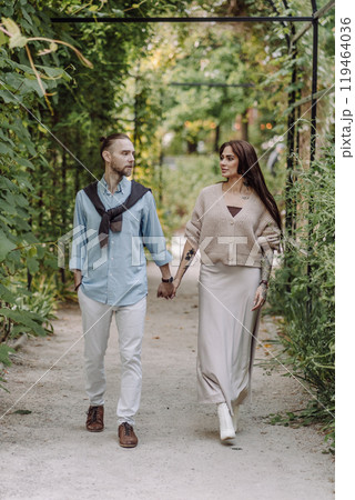Copy space. overs are laughing. Happy guy and girl. Lovers enjoy each other in the evening park. Happy romantic moments of lovely couple in park during dating. Girl with tattoos. 119464036