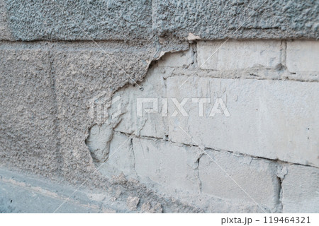 Crumbling Texture of an Aged Concrete Wall with Exposed Bricks and Layered Surfaces 119464321