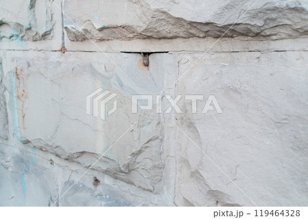 Textured Gray Stone Wall with Visible Cracks and Unique Patterns Textured Gray Stone Wall with Visible Cracks and Unique Patterns 119464328