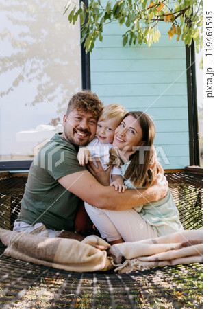 Smiling family enjoying warm embrace together outdoors, capturing essence of love and togetherness 119464545