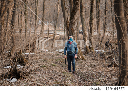 A solitary figure in a tranquil forest setting during early spring 119464775