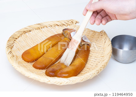 カラスミ作り　焼酎を塗って乾燥 119464950