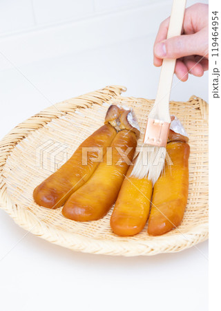 カラスミ作り　焼酎を塗って乾燥 119464954