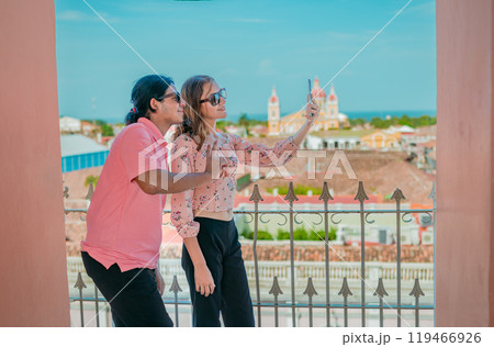 Tourist couple taking a selfie at the viewpoint of the La Merced church. Happy tourists taking self portrait at the viewpoint of the La Merced church, Granada Tourist couple taking a selfie at the viewpoint of the La Merced church. Happy tourists taking self portrait at the viewpoint of the La Merced church, Granada 119466926