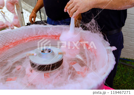 Make pink cotton candy outdoors using machine pan to prepare delicious treats 119467271
