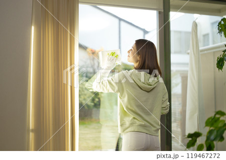 リビングの窓拭きをするミドル女性 119467272