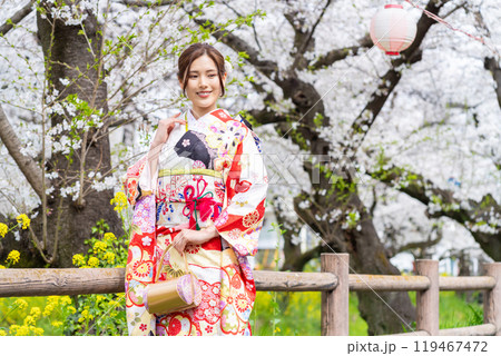 桜満開の中振袖姿の若い女性 119467472