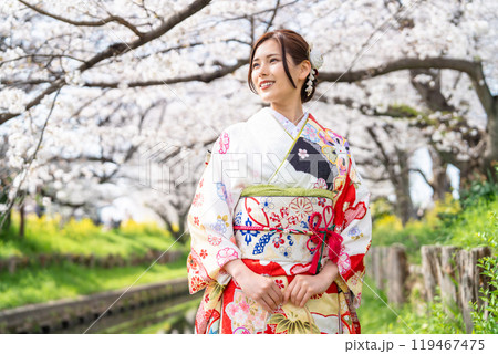 桜満開の中振袖姿の若い女性 119467475