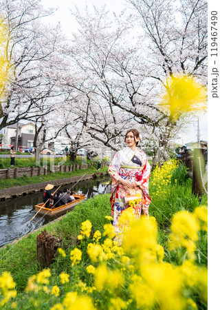 桜満開の中振袖姿の若い女性 119467490