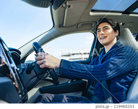笑顔で自動車を運転する男性ドライバーの車内シーン 笑顔で自動車を運転する男性ドライバーの車内シーン 119468101