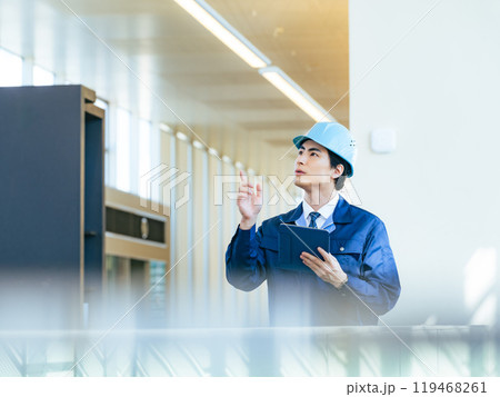 建物の中でタブレットPCを使って点検する男性作業員 建物の中でタブレットPCを使って点検する男性作業員 119468261