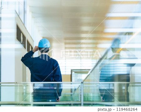 建物の中でヘルメットを被る男性作業員の後ろ姿 建物の中でヘルメットを被る男性作業員の後ろ姿 119468264