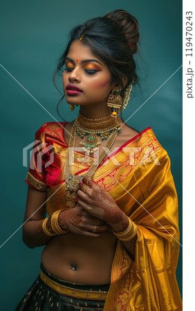 Elegant south indian young woman in traditional indian wear saree with gold jewellery and henna. vertical shot 119470243