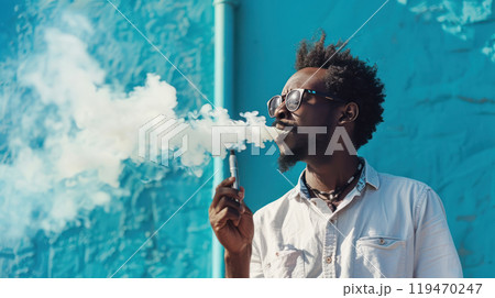 Fashionable black man with vape on bright blue urban background 119470247