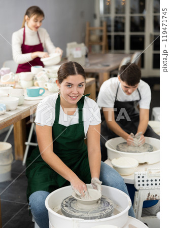 Young woman sculpting product on potter's wheel Young woman sculpting product on potter's wheel 119471745