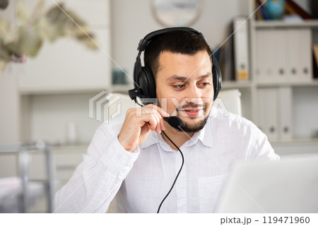 Portrait of positive man office worker wearing headset 119471960