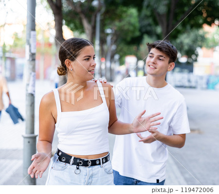 Displeased girl stopping stranger guy flirting with her on city street 119472006