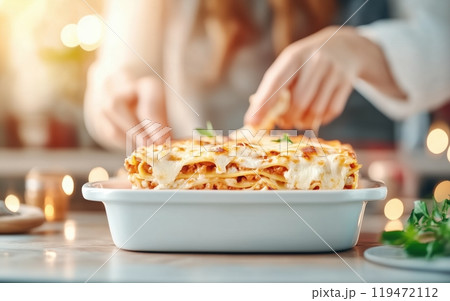 Delicious homemade lasagna served on a white dish, ready to be enjoyed during a cozy meal. 119472112