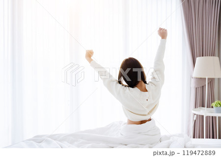 Young Asian Woman stretching in bed after waking up 119472889