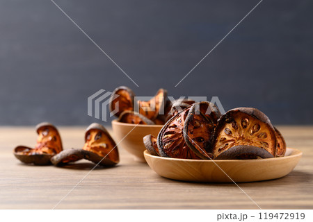 Dried Bael fruit on wooden plate, Herbal drink ingredient 119472919