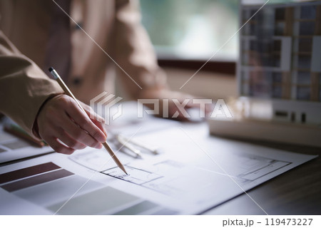 Female architect working and inspection architecture interior of construction project on blueprint Female architect working and inspection architecture interior of construction project on blueprint 119473227