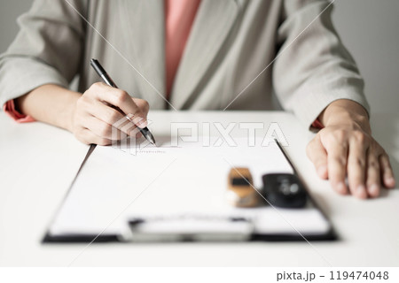 Car dealer businessWoman signing car insurance document or lease paper. Car loan and insurance concept 119474048