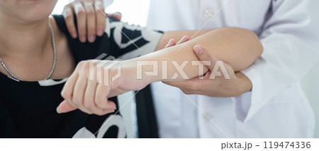 Female physiotherapists provide physical assistance to women patients with elbow injuries examine patients in rehabilitation centers. Physiotherapy concepts Female physiotherapists provide physical assistance to women patients with elbow injuries examine patients in rehabilitation centers. Physiotherapy concepts 119474336