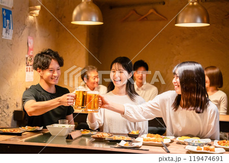 居酒屋でお酒を飲む若い男女 居酒屋でお酒を飲む若い男女 119474691