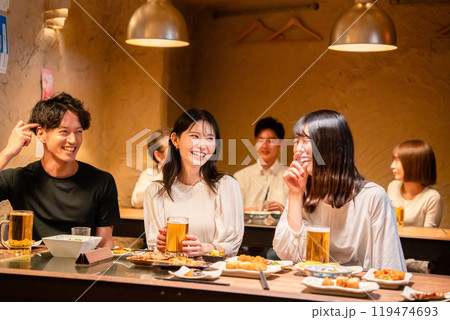 居酒屋でお酒を飲む若い男女 居酒屋でお酒を飲む若い男女 119474693