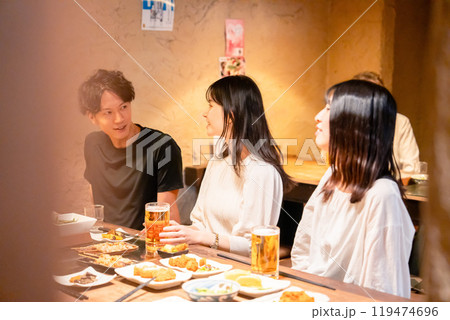 居酒屋でお酒を飲む若い男女 119474696