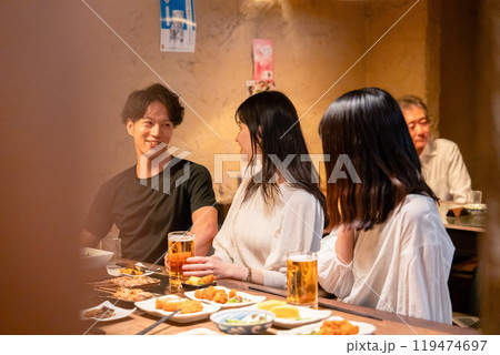 居酒屋でお酒を飲む若い男女 119474697