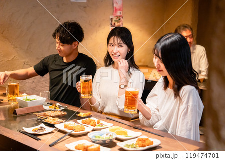 居酒屋でお酒を飲む若い男女 119474701