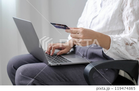 Asian woman shopping online using credit card and using laptop. Entering card number in laptop app to purchase and pay in online store Asian woman shopping online using credit card and using laptop. Entering card number in laptop app to purchase and pay in online store 119474865