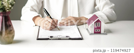 agents working in real estate investment and home insurance signing contracts in accordance with the home buying insurance agreements approving purchases for clients 119474927