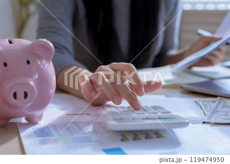 Business woman or accountant working on calculator to calculate business data in modern office. Accounting business woman are calculating analyzing investment data, Financial and tax systems concept Business woman or accountant working on calculator to calculate business data in modern office. Accounting business woman are calculating analyzing investment data, Financial and tax systems concept 119474950