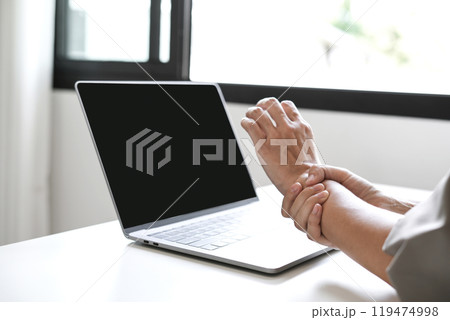 Woman hand with wrist pain numbness and pain in the palm of the hand has pain and tingling in the nerve endings This is a side effect of sitting and working for a long time on a laptop at the office Woman hand with wrist pain numbness and pain in the palm of the hand has pain and tingling in the nerve endings This is a side effect of sitting and working for a long time on a laptop at the office 119474998