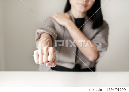 Woman having shoulder pain pain during work long time. stretching to relax and relax while working hard at the office Woman having shoulder pain pain during work long time. stretching to relax and relax while working hard at the office 119474999