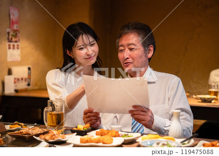 若い女性と二人でお酒を飲む男性 119475088