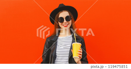 Portrait stylish young woman drinking juice posing in black rock style leather jacket, round hat 119475851