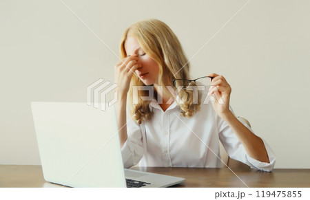 Tired overworked woman employee suffering from headache, rubbing eyes, working with laptop 119475855