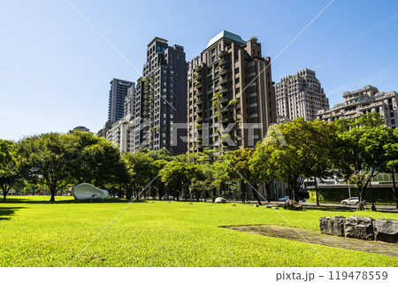Low-angle view of green park space and modern buildings on both sides in downtown Taichung, Taiwan, It is near the National Taichung Theater. 119478559