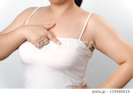 Asian woman checking lumps on her breast for signs of breast cancer on white background Asian woman checking lumps on her breast for signs of breast cancer on white background 119480019