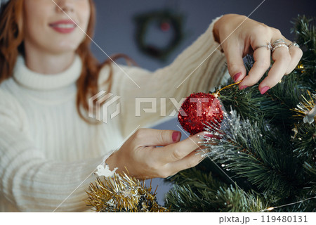 Decorating Christmas Tree with Red Ornament Decorating Christmas Tree with Red Ornament 119480131