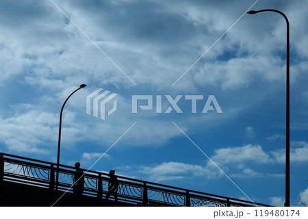 雲の多い空と陸橋と通り人 119480174