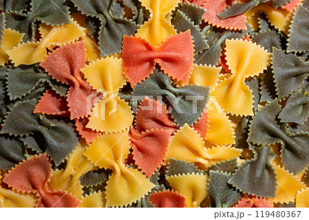 Dry Uncooked Colored Farfalle Pasta and Raw Macaroni on a Textured Background 119480367
