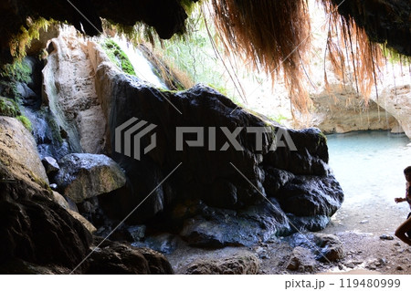 Middle East Jewish scenic inside view from deep cavern. Pure brook flows in dark gorge Ein Gedi, in Judean desert on shore of Dead Sea. Place where judaic warrior David hid from King Saul in Palestine 119480999