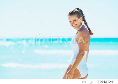 happy young woman walking in sea 119481241