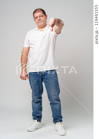 A middle-aged man expressing disapproval with a thumbs-down gesture i 119481555