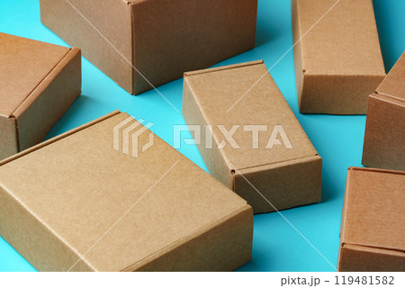 A collection of cardboard boxes arranged on a bright blue surface 119481582